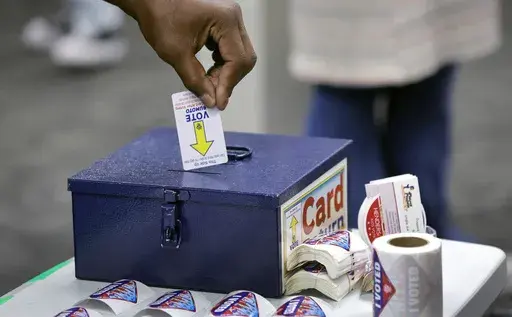 A voter deposits his voting machine activation card into a box after casting his ballot at a polling site at Henderson City Hall Tuesday, Nov. 5, 2024, in Henderson, Nev. (Steve Marcus/Las Vegas Sun via AP, File)