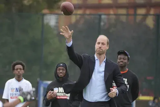 Britain's Prince William throws a football as he attends a NFL Foundation NFL Flag event, an inclusive and fast paced American Football format, in London, Tuesday, Oct. 15, 2024. (AP Photo/Kin Cheung, Pool)