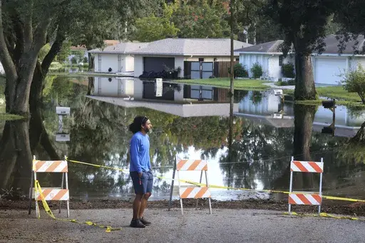 A Spring Oaks resident checks out the rising floodwaters from the Little Wekiva River on Spring Oaks Blvd. in his neighborhood in Altamonte Springs, Fla., Friday, Oct. 11, 2024. Central Florida rivers are forecast to crest in the coming days because of the excessive rainfall from Hurricane Milton. (Joe Burbank/Orlando Sentinel via AP)