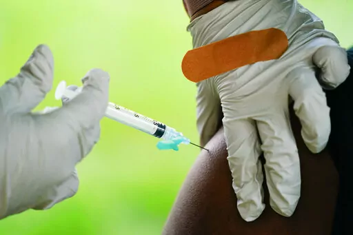 In this Sept. 14, 2021, file photo, a health worker administers a dose of a Pfizer COVID-19 vaccine during a vaccination clinic at the Reading Area Community College in Reading, Pa.   COVID-19 shots during pregnancy may protect babies after their born and lead to fewer infants needing hospitalization. That's according to a U.S. Centers for Disease Control and Prevention study released Tuesday, Feb. 15, 2022. (AP Photo/Matt Rourke, File)