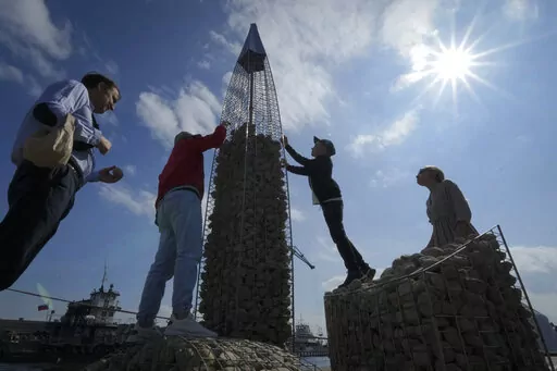 People build a model of the business tower Lakhta Centre, at the headquarters of Russian gas monopoly Gazprom, filling the frame with stones, in St. Petersburg, Russia, Thursday, June 9, 2022. It's not a summer heat wave that's making European leaders and businesses sweat. It's fear that Russia's manipulation of natural gas supplies will lead to an economic and political crisis next winter. Or, in the worst case, even sooner. (AP Photo/Dmitri Lovetsky, File)