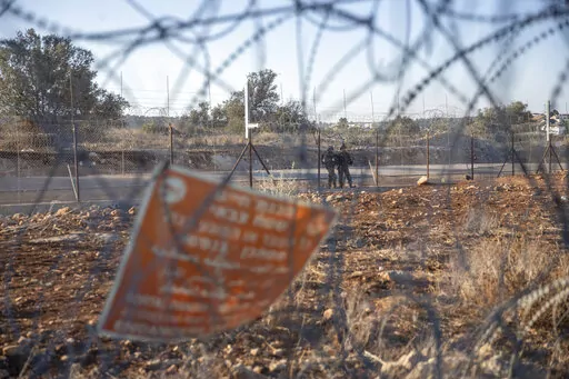 Israeli army soldiers guard a section of Israel's separation barrier, in the West Bank village of Nilin, west of Ramallah, Sunday, Nov. 7, 2021. Two Palestinian men were critically injured by Israeli forces in the occupied West Bank on Monday, the Palestinian Health Ministry said, the latest incident in a wave of Israeli-Palestinian violence during the Muslim holy month of Ramadan. (AP Photo/Nasser Nasser, File)