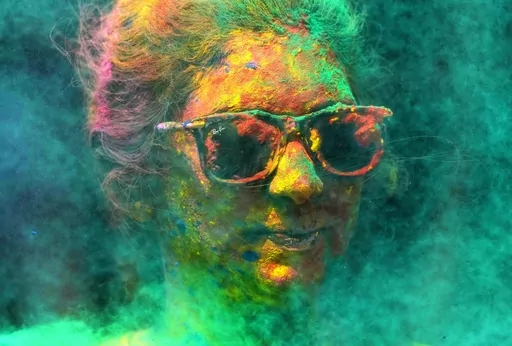 A woman smeared with colors celebrates Holi, the Hindu festival of colors, in Mumbai, India, Tuesday, March 7, 2023. (AP Photo/Rajanish Kakade, File)
