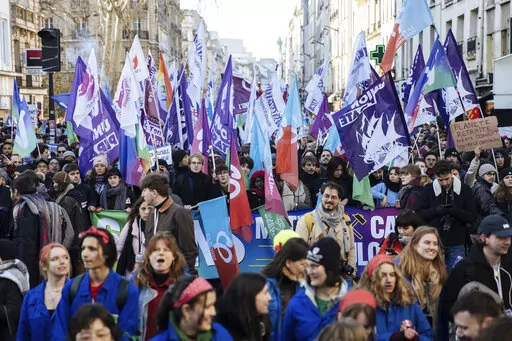 Protestors wave flags during a rally, called by left-wing La France Insoumise (LFI) party and Youth organizations, to protest against the French President's pension reform, in Paris, Saturday, Jan. 21, 2023. (AP Photo/Lewis Joly)