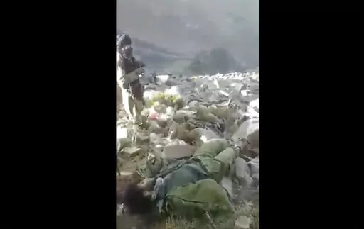 In this frame grab from video that was likely taken by the Taliban and posted online and provided by Afghan Witness, a UK-based open-source nonprofit, a Taliban fighter stands amid bodies on the ground, in the Dara district, of Panjshir province, Afghanistan, Sept. 14, 2022. The Taliban captured, bound and shot to death 27 men in Afghanistan’s Panjshir Valley last month during an offensive against resistance fighters in the area, according to a new report by Afghan Witness published Tuesday, O