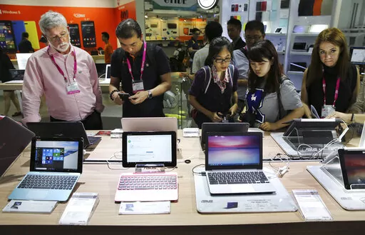 Visitors review new Asus computer products at the Computex trade show in Taipei, Taiwan, Tuesday, June 2, 2015. The U.S. government has announced talks with Taiwan, Thursday, Aug. 18, 2022, on a trade treaty in a new sign of support for the self-ruled island democracy claimed by China’s ruling Communist Party as part of its territory. (AP Photo/Wally Santana, File)