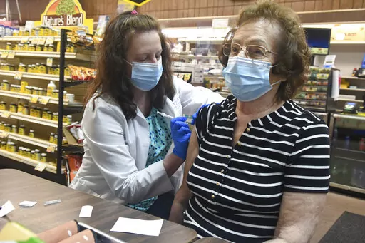 Pharmacist Karen Flynn gives a second Moderna booster shot to her mother Joann Pangonis, of New Boston, Pa., at Morris Drug in Mahanoy City, Pa., on Friday, April 1, 2022.  An extra-contagious version of the omicron coronavirus variant has taken over the world. The variant scientists call BA.2 is now dominant in at least 68 countries, including the U.S. The World Health Organization says it makes up about 94% of sequenced omicron cases submitted in the most recent week to an international databa