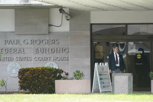 A security guard stands outside the Paul G. Rogers Federal Building and U.S. Courthouse, Thursday, Sept. 1, 2022, in West Palm Beach, Fla. A federal judge heard arguments Thursday on whether to appoint an outside legal expert to review government records seized by the FBI last month in a search of former President Donald Trump's Florida home. There was no immediate ruling. (AP Photo/Wilfredo Lee)