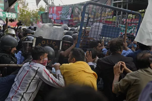 Supporters of former Prime Minister Imran Khan's party scuffle with riot police officers outside Khan's residence, in Lahore, Pakistan, Tuesday, March 14, 2023. Pakistani police scuffled with supporters of former Prime Minister Imran Khan as officers arrived outside his home to arrest him for failing to appear in court on graft charges, police and officials said. (AP Photo/K.M. Chaudary)