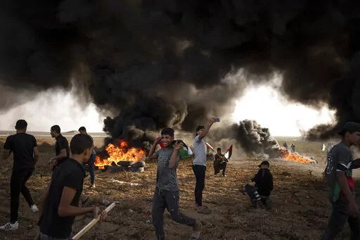 Palestinians burn tires during a protest against Israeli military raid in the West Bank, along the border fence with Israel, in east of Gaza City on Oct. 25, 2022. The U.N. Mideast envoy said 2022 is on course to be the deadliest year for Palestinians in the West Bank since the U.N. started tracking fatalities in 2005, and he called for immediate action to calm "an explosive situation" and move toward renewing Israeli-Palestinian negotiations. (AP Photo/Fatima Shbair, File)