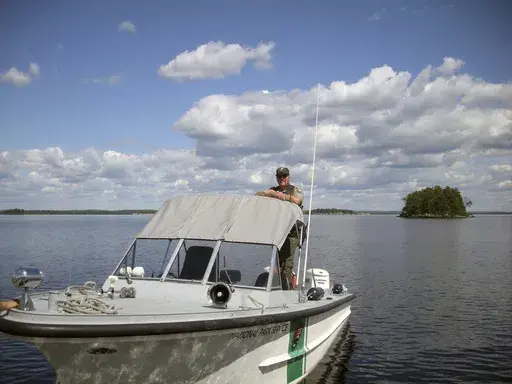 In this undated photo released by the Voyageurs National Park, park ranger Kevin Grossheim, 55, of Kabetogama, Minn., is seen on his boat at Pike Island on Namakan Lake in Voyageurs National Park in northern Minn. (Voyageurs National Park via AP)