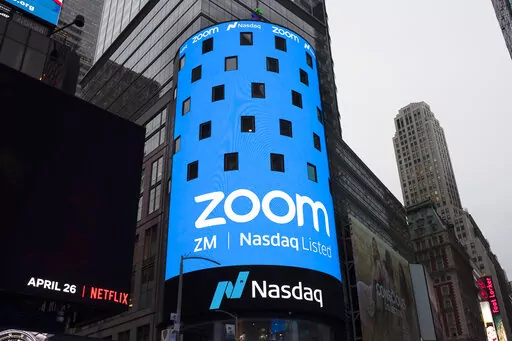 This April 18, 2019, file photo shows a sign for Zoom Video Communications ahead of the company's Nasdaq IPO in New York. The video-conferencing service is cutting about 1,300 jobs, or approximately 15% of its workforce. CEO Eric Yuan said in a blog post Tuesday, Feb. 7, 2023, that the company ramped up staffing during the COVID-19 pandemic, when businesses became increasingly reliant on its service as people worked from home. Yuan said Zoom grew three times in size within 24 months to manage de