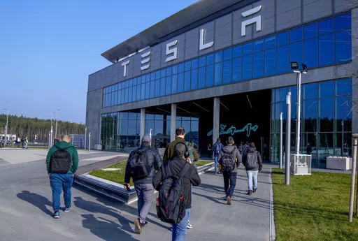 People walk to the Tesla Gigafactory for electric cars in Gruenheide near Berlin, Germany,March 13, 2024. After reporting dismal first-quarter sales, Tesla is planning to lay off about a tenth of its workforce as it tries to cut costs, multiple media outlets reported Monday. (AP Photo/Ebrahim Noroozi, File)