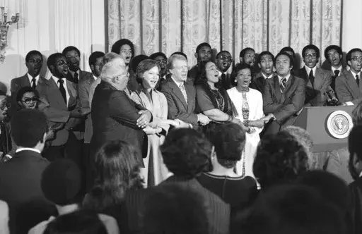 Dr. Martin Luther King Sr., Rosalynn Carter, President Jimmy Carter, Coretta Scott King, Christine Parris King, sister of the late Dr. King, and U.N. Ambassador Andrew Young sing during a reception honoring friends of the Martin Luther King Jr. Center for Social Change in Washington, on Oct. 3, 1978. (AP Photo/Barry Thumma, File)