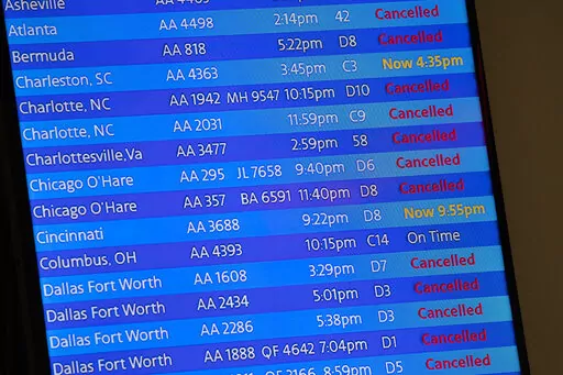 The arrivals board at the American Airlines terminal at LaGuardia Airport displays the flights that have been canceled or delayed and one that is on time, March 21, 2020, in New York. Flight delays and cancellations have bedeviled airline travel so far this year. The Transportation Department is launching a customer service dashboard to assist vacationers ahead of the travel-heavy Labor Day weekend. (AP Photo/Mary Altaffer, File)