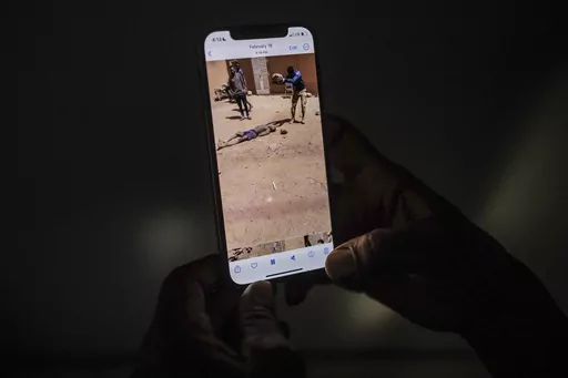 EDS NOTE: GRAPHIC CONTENT - An uncle of a 16-year-old named Adama watches a video in Burkina Faso, Saturday March 18, 2023, showing a man slamming a rock onto the head of his nephew. Burkina Faso has been wracked by violence linked to al-Qaida and the Islamic State group that has killed thousands, but some civilians say they are even more afraid of Burkina Faso’s security forces, whom they accuse of extrajudicial killings. The military junta has denied its security forces were involved, but a 