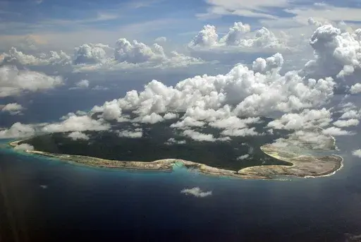 FILE – Clouds hang over the North Sentinel Island, in India's southeastern Andaman and Nicobar Islands, Nov. 14, 2005. (AP Photo/Gautam Singh, File)