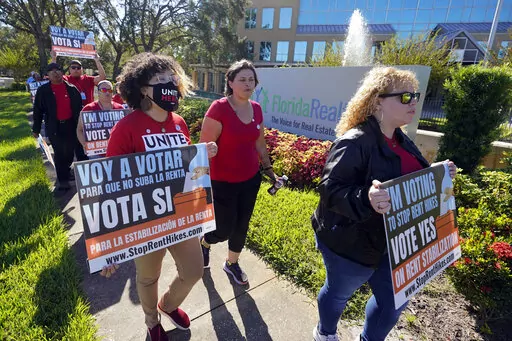 Rent control advocates for Orange County demonstrate in front of the Florida Realtors office building on Oct. 22, 2022, in Orlando, Fla. Ballot measures to build more affordable housing and protect tenants from soaring rent increases were plentiful and fared well in last week's midterm elections. The activity reflected growing angst over record high rents exacerbated by inflation and a dearth of homes. (AP Photo/John Raoux, File)