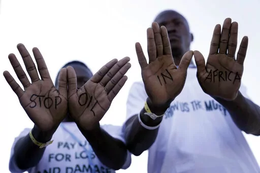 Demonstrators show "stop oil in Africa" written on their hands during a protest with Stop Pipelines coalition against pipelines in East Africa at the COP27 U.N. Climate Summit, Friday, Nov. 11, 2022, in Sharm el-Sheikh, Egypt. (AP Photo/Nariman El-Mofty)