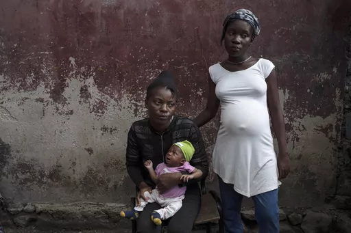 Januelle Datka, her baby girl Princess and her 15-year-old daughter Titti, pose for a photo at a makeshift shelter in Jean-Kere Almicar's front yard, in Port-au-Prince, Haiti, June 4, 2023. Both mother and daughter said they were raped by gang members and that both became pregnant. (AP Photo/Ariana Cubillos, File)