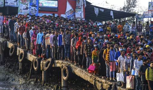 Workers gather in the morning at a boat terminal, waiting to cross the Mongla river, in Mongla, Bangladesh, March 3, 2022. This Bangladeshi town, located near the world’s largest mangrove forest Sundarbans, stands alone to offer new life to thousands of climate migrants. The town was once vulnerable to floods and river erosion. Now it has become more resilient with improved infrastructure and special economic zones to support climate migrants. (AP Photo/Mahmud Hossain Opu)