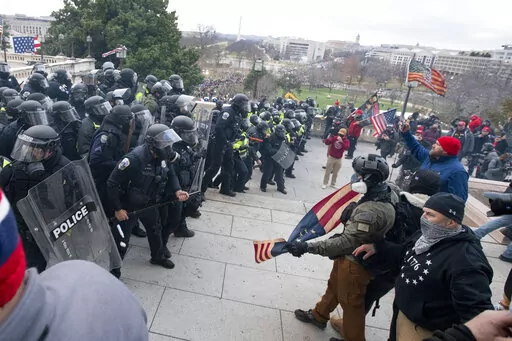 Rioters face off with police at the U.S. Capitol on Jan. 6, 2021, in Washington. A growing number of Capitol riot defendants are pushing to get their trials moved out of Washington. They claim they can't get a fair trial before unbiased jurors in the District of Columbia. (AP Photo/Jose Luis Magana, File)