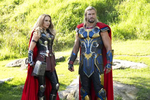 This image released by Marvel Studios shows Natalie Portman, left, and Chris Hemsworth in a scene from "Thor: Love and Thunder." (Jasin Boland/Marvel Studios-Disney via AP)