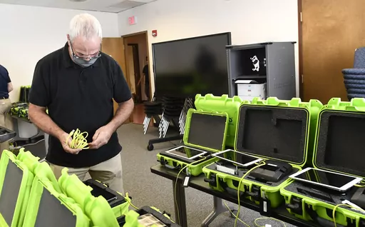 Mark Splonskowski assembles electronic poll book kits that voters will use to sign in at polling locations at the Albany County Board of Elections building, Oct. 14, 2020, in Albany, N.Y. An effort to create a national testing program for technology central to U.S elections will get underway later this year. The aim is to strengthen the security of equipment that's been targeted by foreign governments and that's provided fertile ground for conspiracy theories. (AP Photo/Hans Pennink, File)