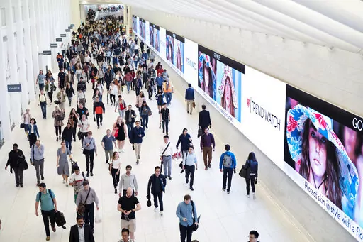 Commuters walk through a corridor in the World Trade Center Transportation Hub in New York on June 21, 2019. The pandemic’s Great Resignation has produced a Great Reinvention as more people of all ages have given up on jobs and find themselves pondering the work-life balance that lends meaning to their lives. (AP Photo/Mark Lennihan, File)