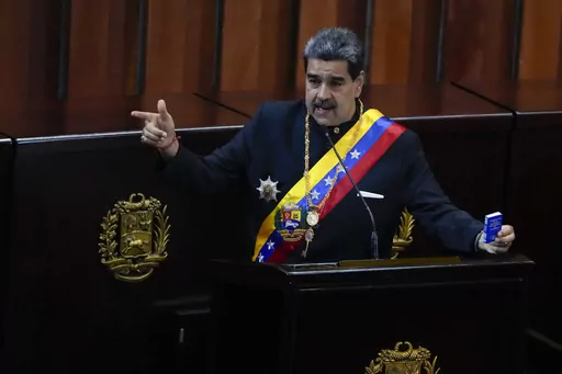 Venezuelan President Nicolas Maduro holds a small copy of his nation's constitution during ceremony marking the start of the judicial year at the Supreme Court in Caracas, Venezuela, Jan. 31, 2024. A secret memo obtained by The Associated Press details a covert operation by the U.S. Drug Enforcement Administration that sent undercover operatives into Venezuela to record and build drug-trafficking cases against the country’s leadership including Venezuelan President Nicolás Maduro. (AP Photo/A