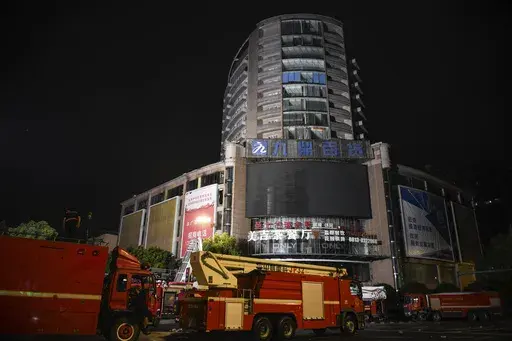 In this photo released by Xinhua News Agency, fire engines are parked near a department store in Zigong City, southwest China's Sichuan Province on Thursday, July 18, 2024, following Wednesday's deadly fire at the department store. (Wang Xi/Xinhua via AP)